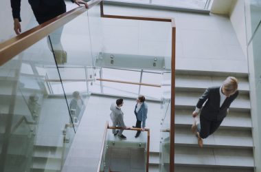 Aerial view of professionals conversing in a glass staircase in a modern office. — Elevate Your Agency with White Label SEO S