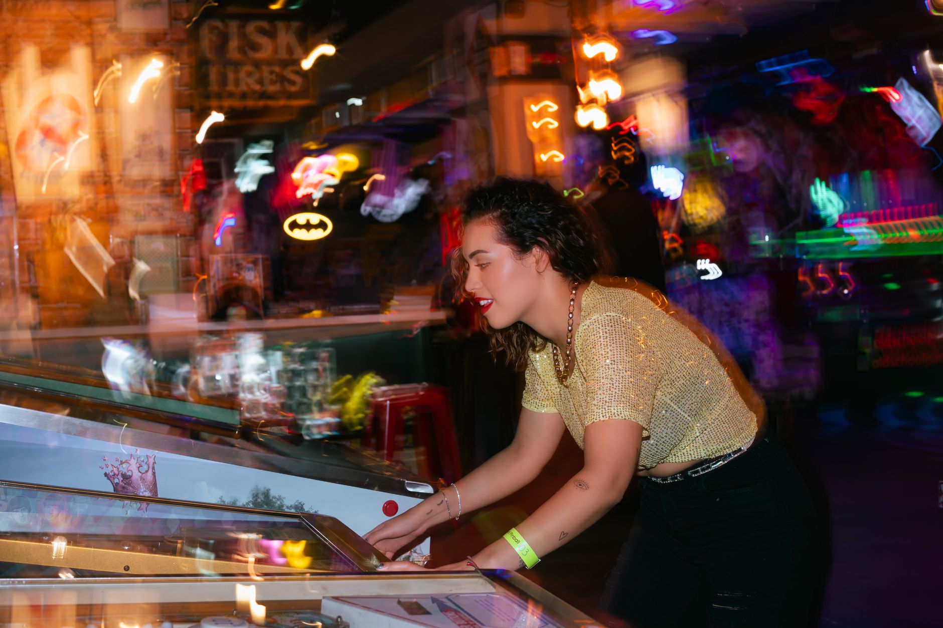 Young woman enjoying a night out playing pinball in an energetic arcade setting. — Win Jackpots on Mega888 Singapore!